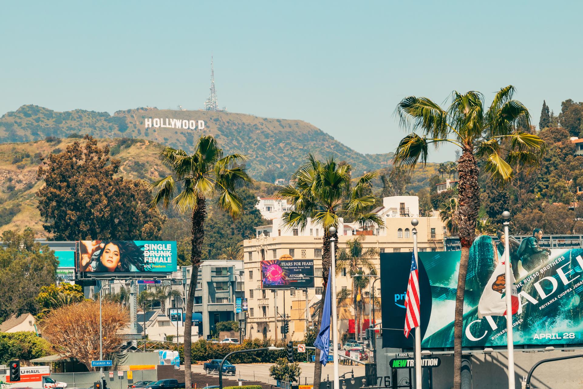 Hollywood hills and Hollywood sign, colorful billdboards, palm trees, traffic, tourists. Hollywood, Los Angeles, California